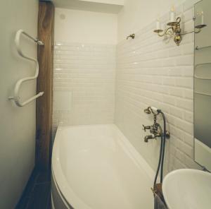 a bathroom with a bath tub and a sink at Krastmala in Liepāja