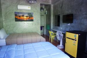 a bedroom with a bed and a desk and a tv at Nadapa Resort in Ko Tao