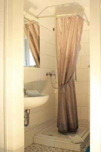 a bathroom with a sink, toilet and shower curtain at Sandbank 134 in Cuxhaven