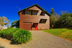 a wooden house with a red door on a driveway at Possum Lodge At Cloudhill Estate in Mount Tamborine