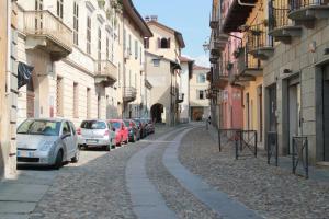 uma rua da cidade com carros estacionados e edifícios em B&B Chiara em Biella