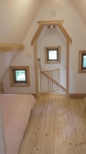 a bedroom with a bed and a wooden floor at WillowTree Cottage in Avèze