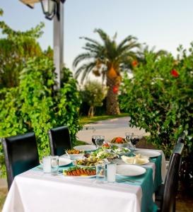 a table with plates of food and glasses of wine at City's Hill Hotel in Kuşadası