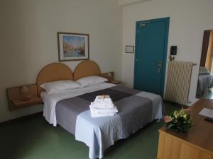 a bedroom with a large bed with a blue door at Hotel Stella Maris in Grado