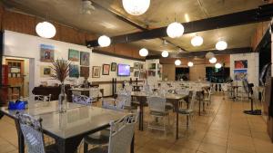 a dining room with tables and chairs and lights at Loreland Farm Resort in Antipolo