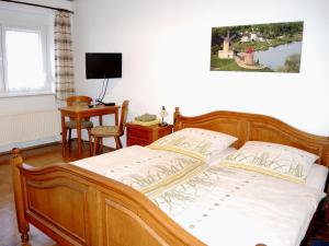 a bedroom with a bed and a desk and a television at Hotel Alte Münze in Gifhorn
