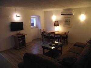 un salon avec un canapé et une table dans l'établissement Apartments Dobrinj, à Dobrinj