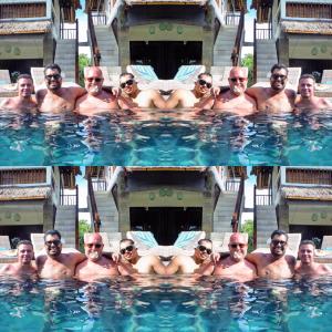 a group of men sitting in a swimming pool at Hill Dance Bali American Hotel in Jimbaran