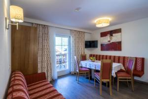 un salon avec une table, des chaises et un canapé dans l'établissement Villa Volgger, à Mayrhofen