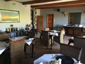 a dining room with tables and chairs and a piano at Smart Villa Guest House in East London