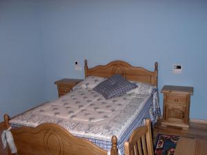 um quarto com uma cama de madeira e uma cómoda de madeira em Hotel O Forno em Salcedo