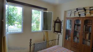 sypialnia z łóżkiem i 2 oknami w obiekcie Kalampakas Guesthouse w Larnace