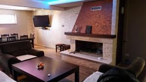 ein Wohnzimmer mit einem Kamin und einem TV in der Unterkunft Holiday House Krizanovic in Domanovići