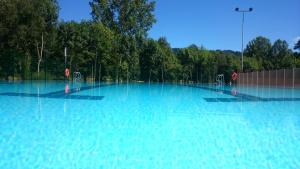 een groot zwembad van blauw water met bomen op de achtergrond bij Casa do Xastre in Baralla
