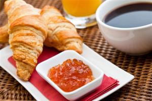 a plate of croissants and a bowl of jam on a table at Hotel Montana Paris Lafayette in Paris