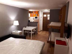 ein kleines Zimmer mit einem Bett und einem Tisch sowie einer Küche in der Unterkunft Matterhorn Studio in Breuil-Cervinia