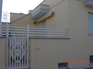 a white fence on the side of a house at Casa Vacanze Manila in Marina di Mancaversa