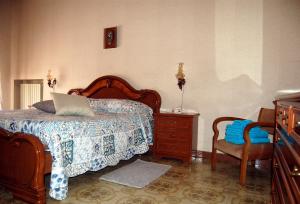 ein Schlafzimmer mit einem Bett, einer Kommode und einem Stuhl in der Unterkunft Casa Fontana in Modica