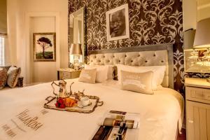 a bedroom with a bed with a tray of food on it at The Villa Rosa Hotel & Self-catering Apartments in Cape Town
