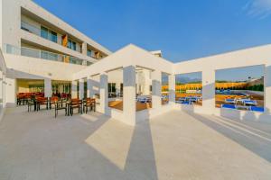 a large building with a patio with tables and chairs at Kosher Hotel Franca in Tivat