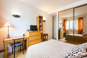 a bedroom with a bed and a desk with a computer at Chambre d'hôtes La Merciere in Lyon