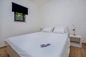 a white bed in a room with a window at Villa David in Rovinj +16 photos