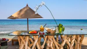 a table with a drink on the beach at Qunci Villas Resort in Senggigi