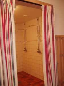 a bathroom with a shower withkered curtains in it at Åbyggeby Landsbygdscenter in Ockelbo