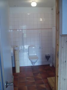 Habitación con suelo de baldosa y baño con aseo. en Åbyggeby Landsbygdscenter en Ockelbo