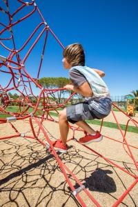 a young boy is playing on a playground at NAU Salema Beach Village in Salema