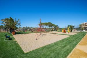 a park with a playground with people playing on it at NAU Salema Beach Village in Salema