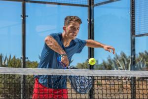 a man hitting a tennis ball on a net at NAU Salema Beach Village in Salema