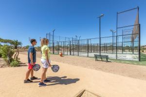 two people standing on a basketball court with rackets at NAU Salema Beach Village in Salema
