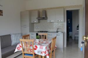 a kitchen with a table and chairs and a kitchen with a table and a table at Sea Garden Rooms in Termoli