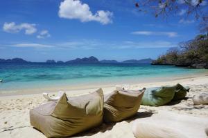 a group of bags sitting on the beach at Vellago Resort in El Nido