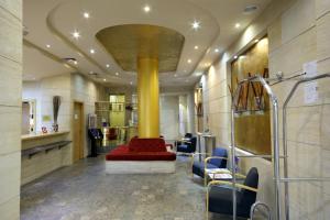 a lobby with a red couch and a yellow column at Silken Alfonso X in Ciudad Real