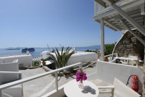 a vase of flowers sitting on a table on a balcony at Mykonos View Hotel in Mýkonos City