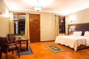 a bedroom with a bed and a table and chairs at Salinero Millie Lodge Machame in Machame