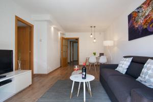 ein Wohnzimmer mit einem Sofa und einem Tisch in der Unterkunft Tendency Apartments Fira in Hospitalet de Llobregat
