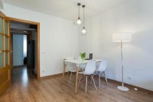 ein Esszimmer mit einem Tisch und weißen Stühlen in der Unterkunft Tendency Apartments Fira in Hospitalet de Llobregat