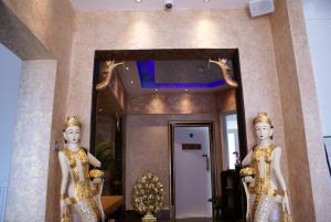 two statues in front of a hallway with a mirror at Loughborough Grange Guesthouse & Spa in Loughborough