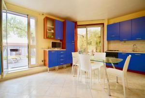 a kitchen with blue cabinets and a table and chairs at Villa Vittoria in Cefalù