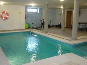 a large swimming pool in a building with a pool at Posada la Desmera in Isla