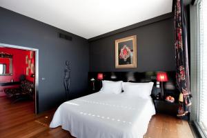 a bedroom with a white bed and a black wall at Farol Hotel in Cascais