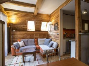 a living room with a couch and a kitchen at TatryTop Apartament Grama in Zakopane