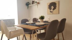 a dining room table with chairs and a wooden table with wine glasses at Caputxins Apartment in Tarragona