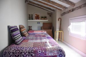 a bedroom with a bed with a purple comforter at 18 Torres in Zaragoza