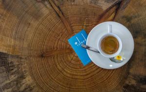 a cup of coffee and a book on a table at Island Boutique Hotel in Larnaca