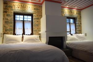a bedroom with two beds and a fireplace at Argiades in Elati Zagori