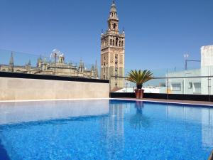 a large swimming pool with a large clock tower at Hotel Casa 1800 Sevilla in Seville